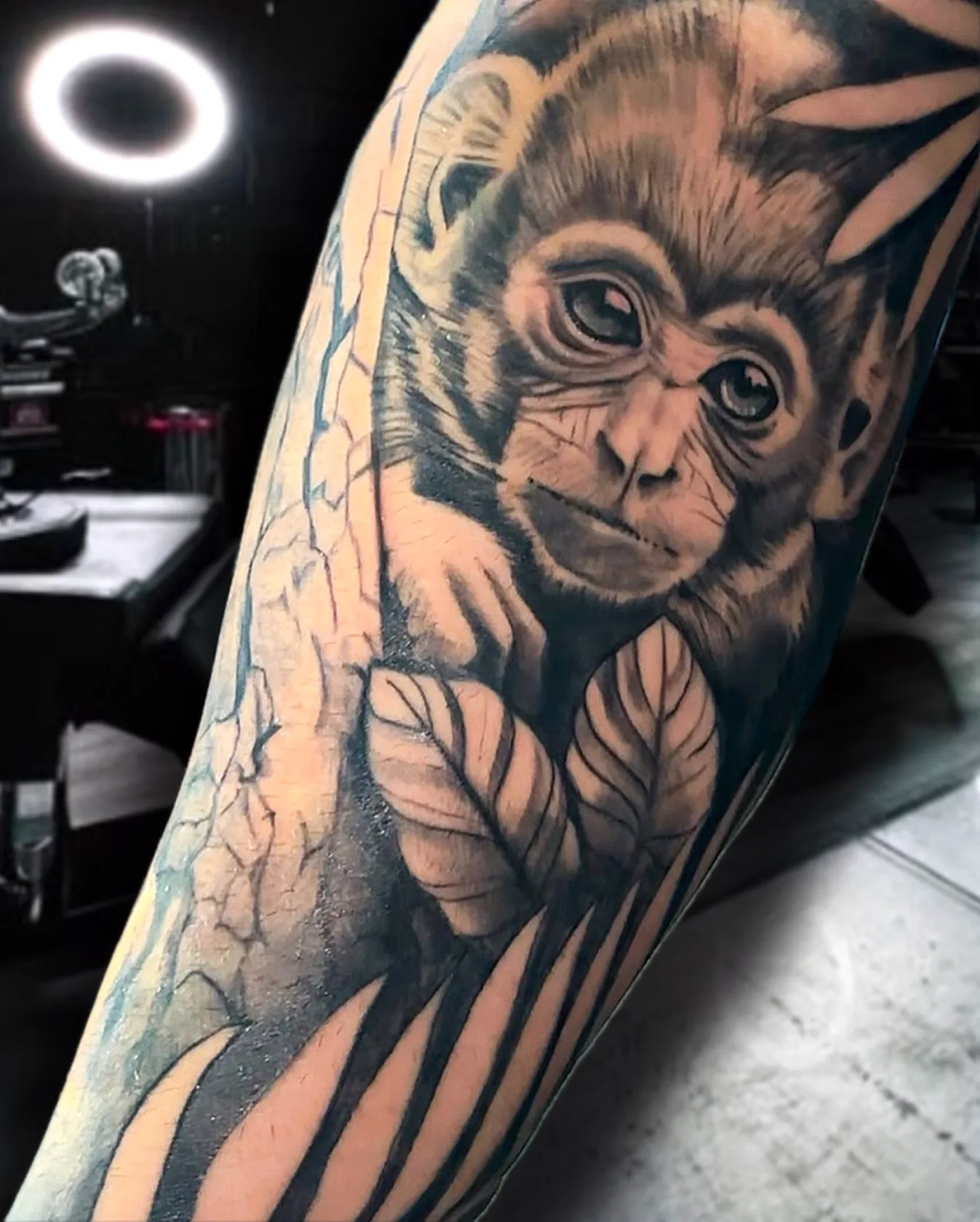 Black and grey monkey tattoo as part of an arm sleeve